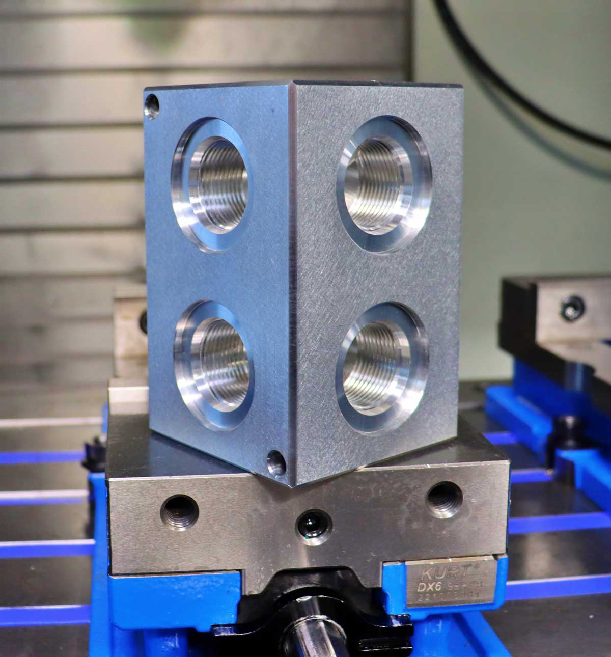 cnc machined metal cube with four machined holes
