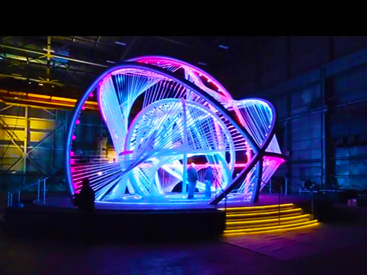 metal frame sphere sculpture lit up with blue and purple